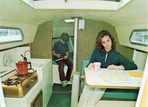 View of Interior Cabin of O'Day 23 While Mom Charts a Course and a Youngster Plays in the Background.