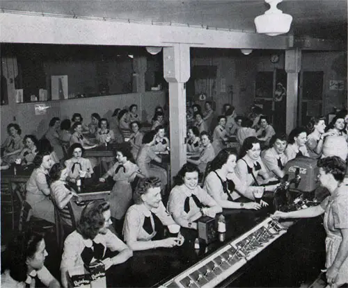 “Have a Coke . . . Indulge in a Hot-Fudge Sundae” . . . Ship’s Fountain, a Favorite “Hangout” Anytime of Every Day.