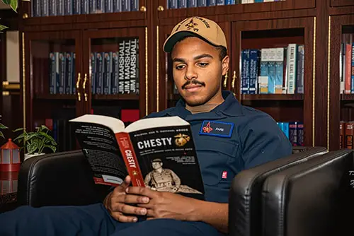 U.S. Navy Sailor Reading in USS George H.W. Bush Library, 2024.