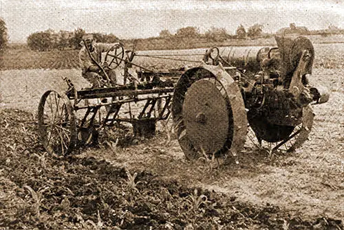 GGA Image ID # 1970224971 Farmer Is Using an All-around Tractor with a Cultivator.