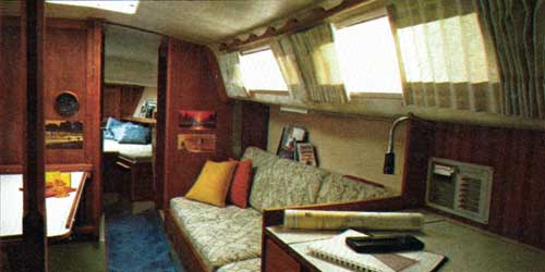 The CAL 34-III Yacht Below Decks view of the traditional teak-paneled main cabin.