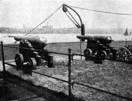 BRASS GUNS ON THE WHARF AT THE ROYAL VICTUALLING YARD