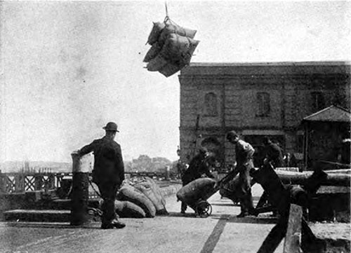 LOADING A LIGHTER WITH BAGS OF SUGAR.