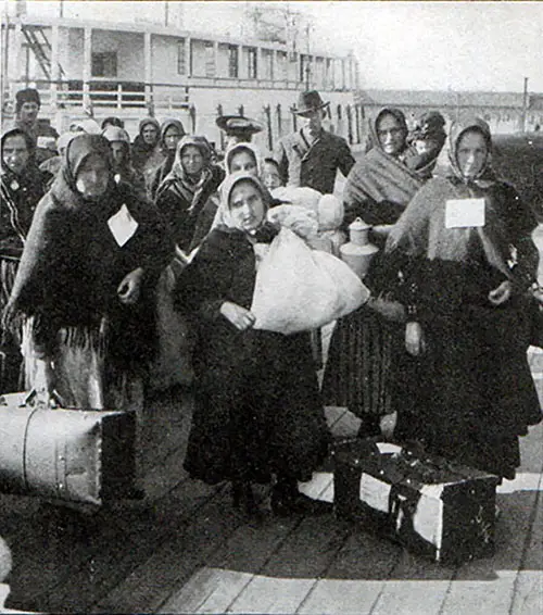 Immigrants arrive via Ferry at Ellis Island circa 1910.