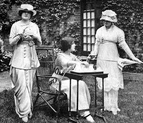 The guest enjoying the cup of tea is wearing a simple frock of gray silk cashmere with sash and buttons of the material.