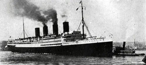 View of the SS France near port, guided by Tugboats.