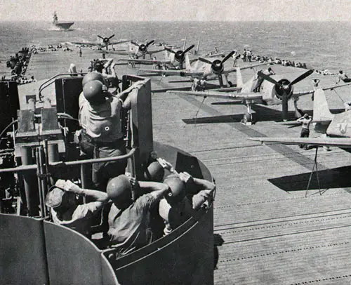 ON THE ALERT—Carrier men scan sky as F6F Hellcats line flight deck in WW II.