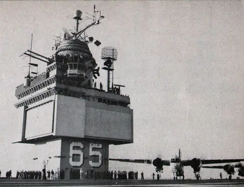 Crew members watch carrier's first aircraft launching.