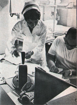 Navy nurse Hill checks patients' medical records with corpsman.