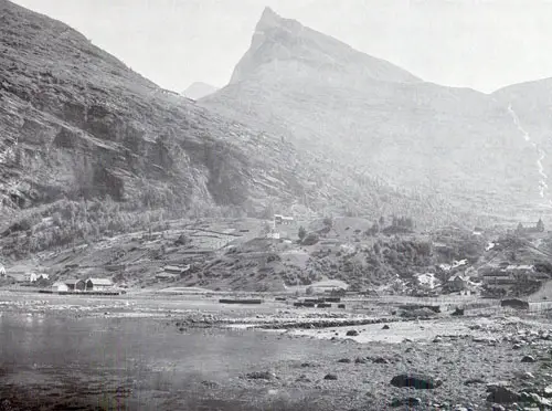 Photo 102: View of the village of Merok as seen from across the Fjord. Visable are a number of farm buildings, Church and the village of Merok on the far right side. 