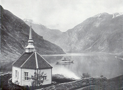 Photo 095: The SS Meteor in Geiranger Fjord with view of Stave Church in the foreground. 