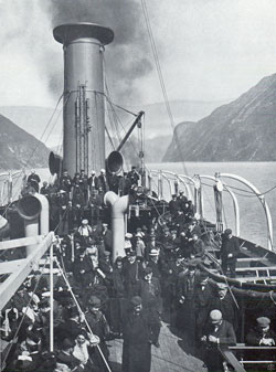 Photo 096: The SS Meteor in Geiranger Fjord view of immigrants and tourist passengers on deck.