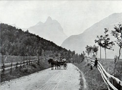 Photo 047: Morning in Romsdal Horn. Scene depicts a traditional mode of transportation, the Stolkjaerre or two wheeled, horse-drawn buggie, a common sight throughout Norway. 