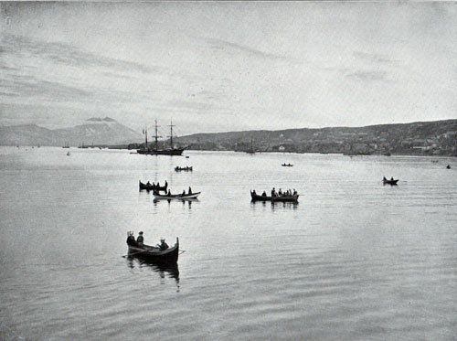 Photo 058: Tromsø in the light of the midnight sun. Small watercraft in foreground and unidentified steamship in background.