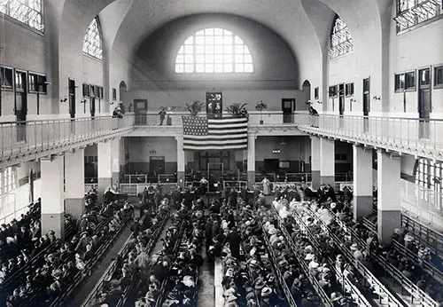 Immigrants Seated on Long Benches in the Main Hall at Ellis Island.