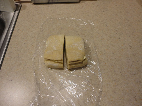 Step 11: Cut the Folded Kringle Dough in Half and Place in Plastic Wrap.
