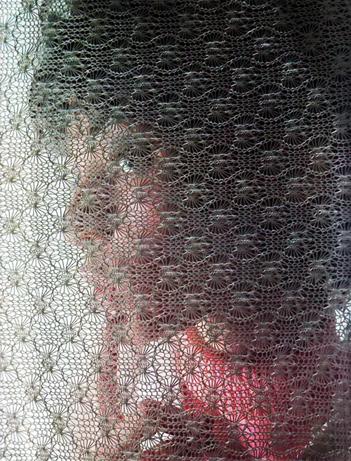 Bright-eyed young lady screened by a knitted fabric produced by Bangor Punta - 1968 Annual Report