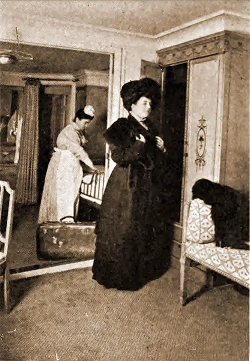 Modern First Class Stateroom Where a Maid Checks the Bedding and Linen Supplies While the Passenger Prepares for a Walk on the Promenade Before Retiring for the Evening.