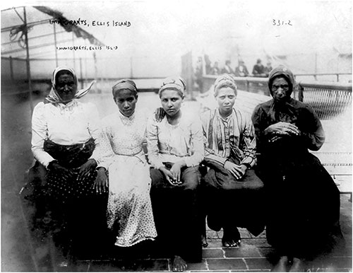 Five Female Immigrants Sitting on the Dock at Ellis Island. ca 1910 George Grantham Bain.