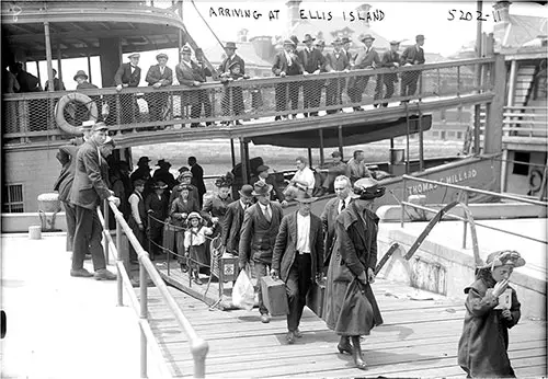 Immigrants Disembarking From the Ferry Begin Their Walk to the Entrance of Ellis Island Circa 1915.
