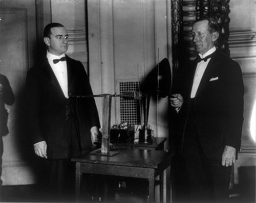 Marchese Guglielmo Marconi, 1874-1937 Standing with Alfred N. Goldsmith, Facing Left with Telegraph Equipment on Table.