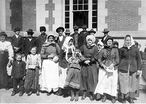 Immigrants Posing for a Photograph Outside a Building at Ellis Island. nd, circa 1912.