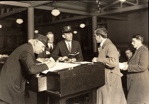 Interpreter and Recorder Interviewing Newcomers to Ellis Island, 1908.