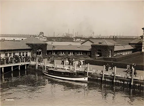 Out Buildings Near Ellis Island Pier; Immigrants Can be Seen with Trunks and Luggage. nd, ca 1908