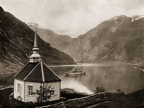 The SS Meteor in Geiranger Fjord with View of Stave Church in the Foreground.