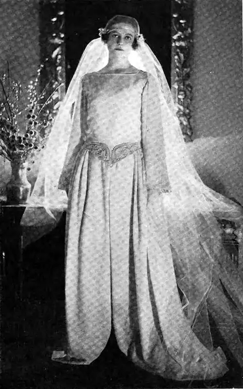 Mlle. Marguerite de Montgolfier, Bride of Baron Roger de Longuerue, Wears a Gown of Chiffon Velvet Over Silver and a Draped Tulle Veil. Vogue Magazine, 1 April 1922.