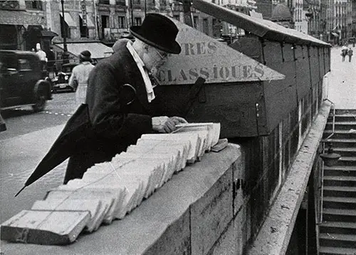 A Man Views Book for Sale in One of the Many Small Kiosks that Line the Seine in Paris.