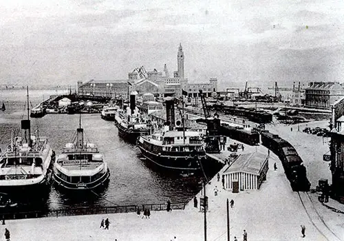 Steamships Docked at the Landing Stage at Cherbourg-Octeville. Train Station is in the Far Background.