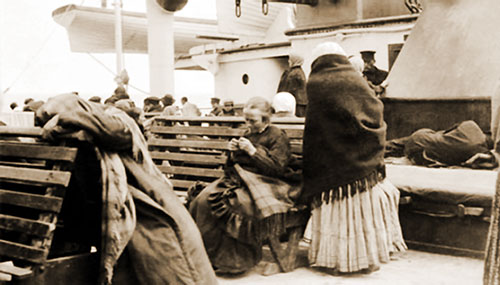 View of the Steerage Promenade on the Titanic. Benches Line the Side and a Gathering of Third-Class Passengers Appears in the Background.