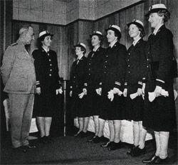 Rear Admiral Randall Jacobs, USN, Chief of the Bureau of Naval Personnel, inspects the new uniforms of the Women’s Reserve.