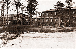 Men from Battery F, 303rd Heavy Field Artillery. Barracks Shown in Background.