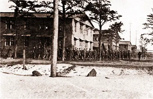 Battery D of the 303rd Heavy Field Artillery Rounds the Corner Wearing Blue Overalls to Keep Their Uniforms From Getting Dirty.